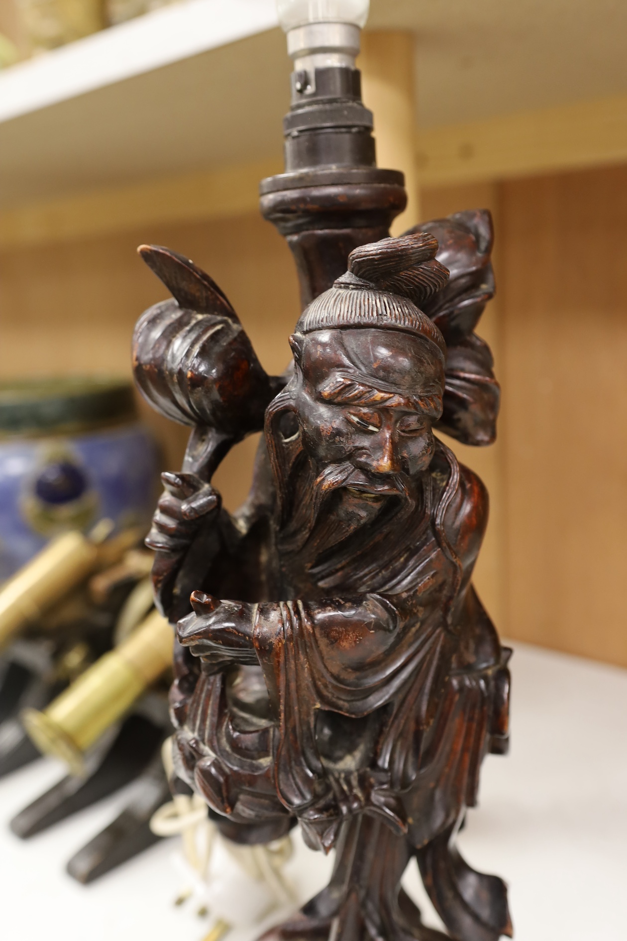 A Chinese carved wooden figural table lamp base, 36cm high not including light fitting. Condition - rubbed in places